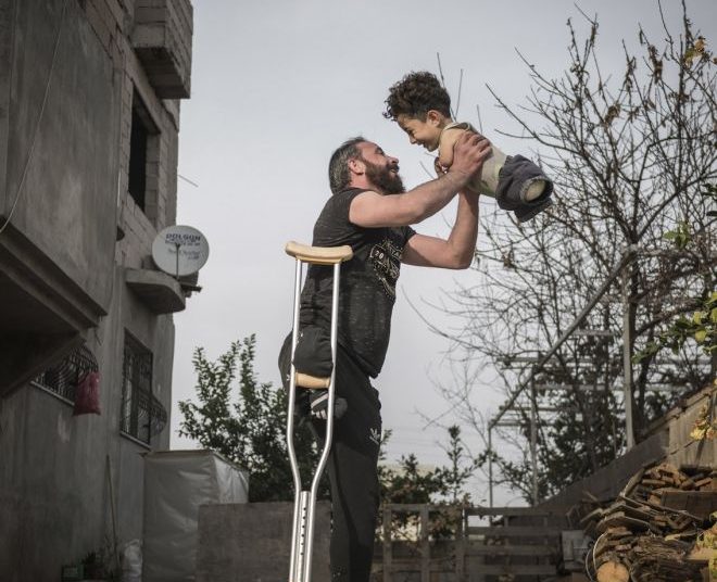 H φωτογραφία της χρονιάς – Η εικόνα-γροθιά στο στομάχι πατέρα και γιου με φόντο τον πόλεμο στη Συρία